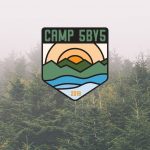 A forest of pine trees on a foggy day with the Camp 5by5 Logo as an overlay