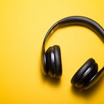 A pair of headphones over a yellow background