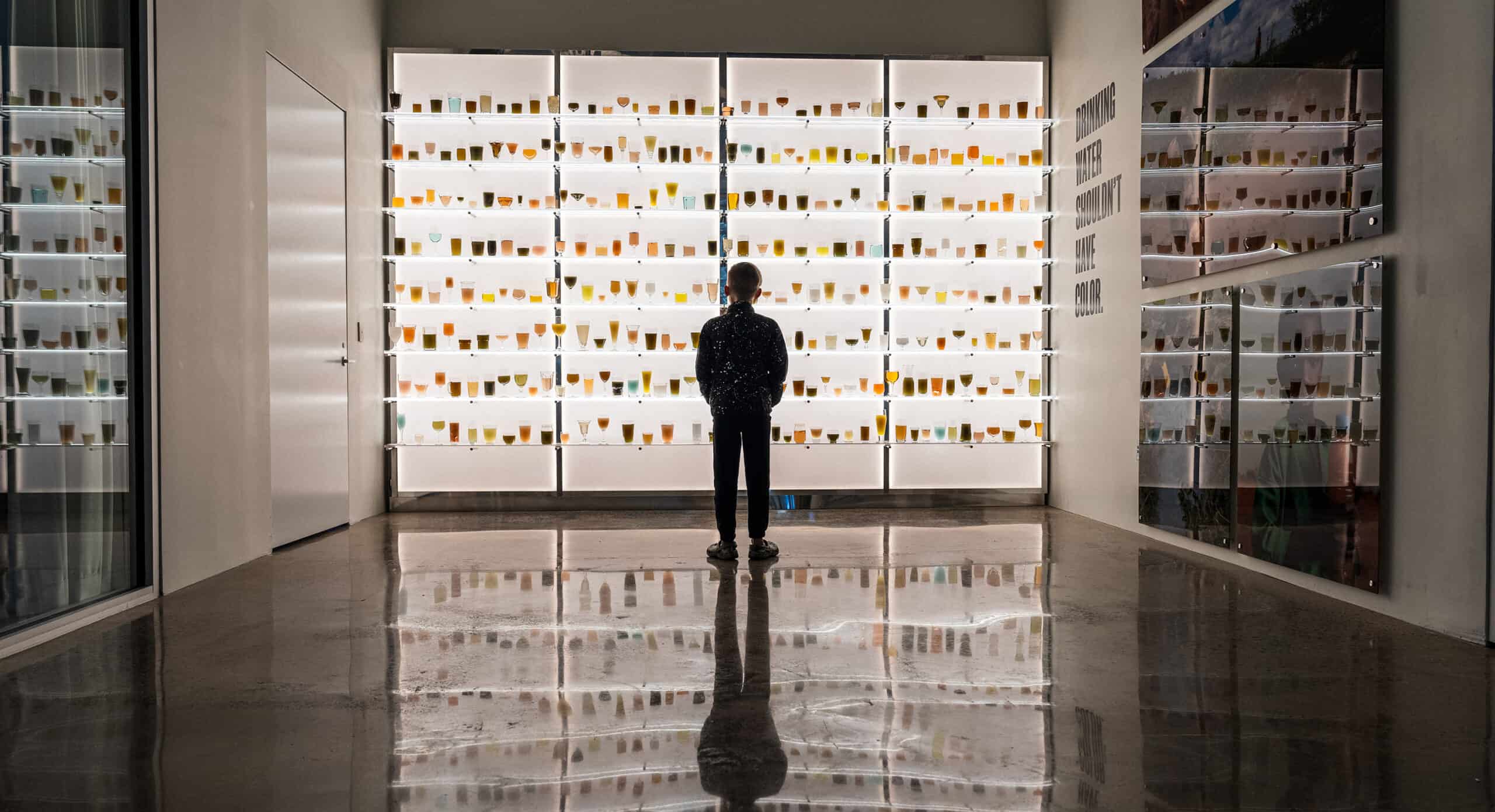 A child looking at a wall of glasses at charity:water's Experience Lab